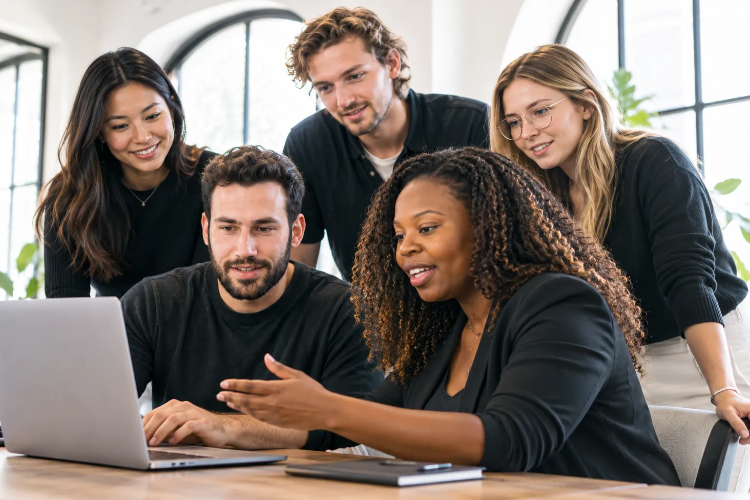 The Slickview Studios team collaborating around a laptop